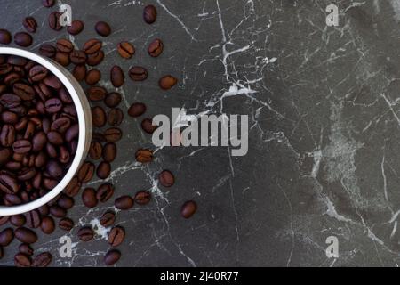 Kaffeebohnen und frisch gerösteter Kaffee in einer Tasse auf abstraktem und farbenfrohem Hintergrund Stockfoto