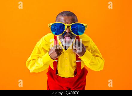 Cooler älterer Mann mit modischem Porträt im Bekleidungsstil auf farbigem Hintergrund - Lustiger alter Rentner mit exzentrischem Stil, der Spaß hat Stockfoto