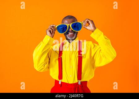 Cooler älterer Mann mit modischem Porträt im Bekleidungsstil auf farbigem Hintergrund - Lustiger alter Rentner mit exzentrischem Stil, der Spaß hat Stockfoto