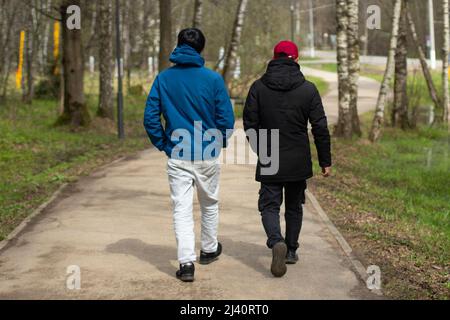Zwei Männer gehen auf Geschäft. Die Stadtbewohner suchen einen Weg. Männer gehen auf das Ziel zu. Die Menschen gehen durch neues Territorium. Stockfoto