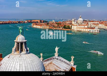 Blick von oben auf die Statue auf der Kuppel der Kirche San Giorgio Maggiore mit Blick auf den Kanal und die Altstadt von Venedig, Italien. Stockfoto