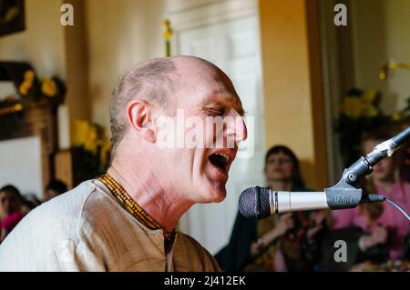 28.. Februar 2010. Inis Rath, Fermanagh, Nordirland. Ein Hare-Krishna-Anhänger in einer verblassten Robe singt während einer Tempelzeremonie Stockfoto