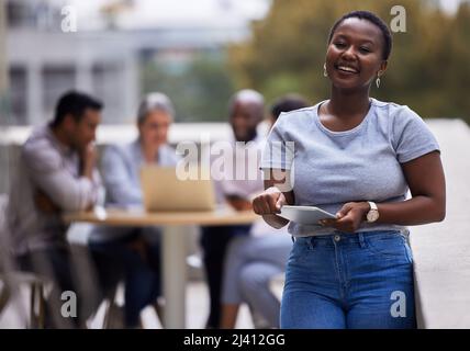 Beschränken Sie sich nicht. Aufnahme einer jungen Geschäftsfrau, die vor dem Büro steht. Stockfoto