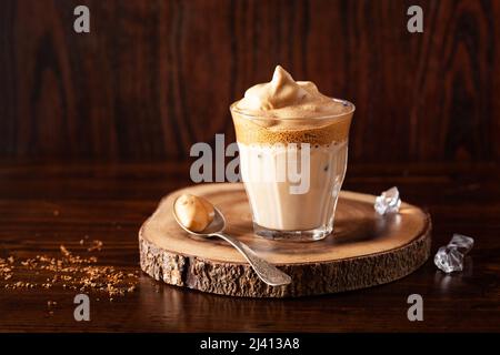 Dalgona Kaffee im Glas. Trendy Instant Kaffee mit Zucker und heißem Wasser peitscht Stockfoto