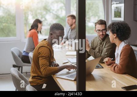 Das multinationale Business-Team arbeitet in einer modernen Halle der Kuhhirten Stockfoto