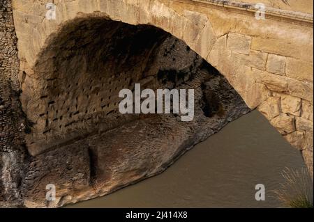 Putlog oder Putlock-Löcher für Gerüste, die von jahrhundertelangen Reparaturen unter dem Eselrücken der römischen Brücke aus dem 1.. Jahrhundert n. Chr. über den Fluss Ouvèze bei Vaison-la-Romaine im Vaucluse, Provence-Alpes-Côte d'Azur, Frankreich, zurückgelassen wurden. Die Brücke hat Kriege, Invasionen, Erosion überlebt und wurde 1992 von einer Mauer aus Wasser getroffen, während katastrophale Überschwemmungen, die neuere Brücken zerstörten. Stockfoto