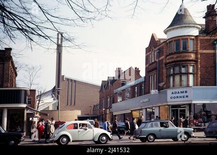 Autos wie VW Volkswagen Bettle und Einkäufer in Adams Corner und St. Dunstans Modern Church, Kings Heath, Birmingham, West Midlands, England, GROSSBRITANNIEN 192 Stockfoto