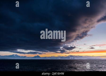 Am frühen Morgen fällt Licht auf die Berggipfel an der Küste von Danco, über die Gerlache-Straße, nördlich von Renard Island, Antarktische Halbinsel Stockfoto