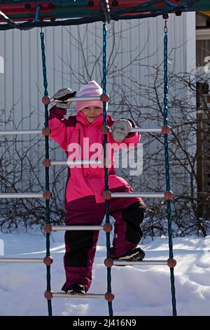 Umea, Norrland Schweden - 12. März 2022: Ein kleiner Junge steigt in eine Spielposition Stockfoto