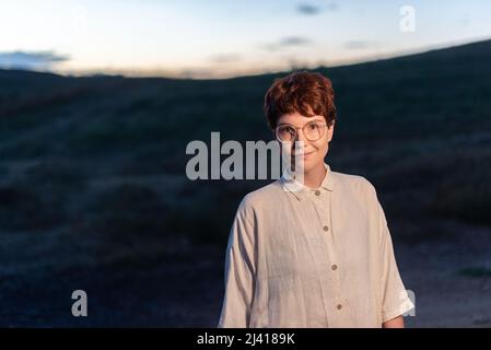 Porträt einer nicht-binären Frau draußen in der Abenddämmerung Stockfoto