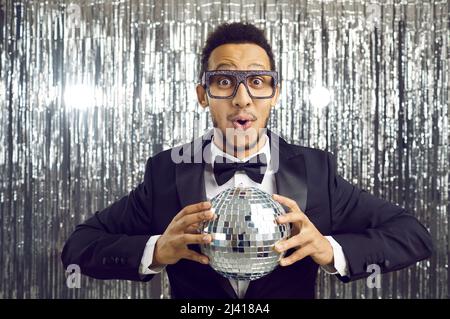 Afroamerikanischer Mann mit Diskokugel in den Händen Stockfoto