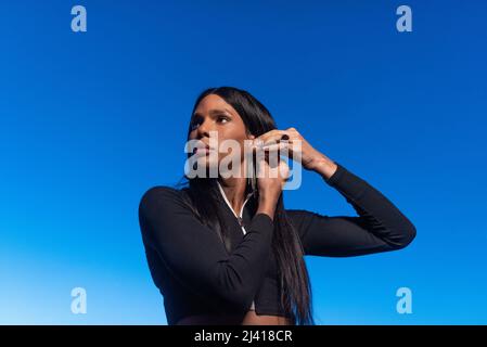 Transsexuelle Frau, die einen Ohrring trägt, während sie zur Seite schaut Stockfoto