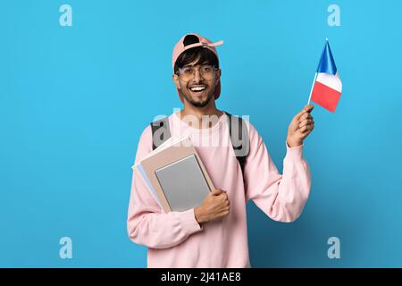 Glücklicher arabischer Student, der die Flagge Frankreichs zeigt Stockfoto