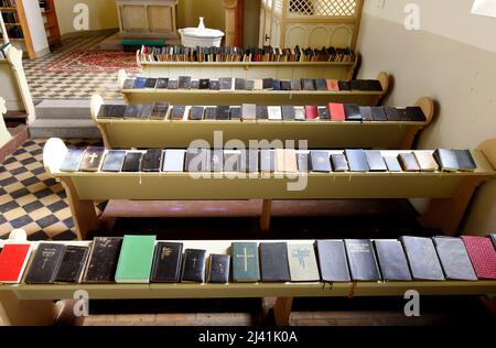 08. April 2022, Sachsen-Anhalt, Luso: In der Gesangskirche liegen rund 2000 Gesangssammelte auf den Bänken und auf Holzregalen. Die Hymnenkirche ist Teil von drei weiteren Themenkirchen in den Vororten, einer Osterkirche, einer Weihnachtskirche und einer Bibelkirche und soll neue Besucher in die alten, ungenutzten Gotteshäuser bringen. Die Hymnen sind in vielen Sprachen und Versionen zu sehen. Die Themenkirchen sollen historische Entdeckungen einladen, spirituelle Begegnungen und Raum für innere Kontemplation bieten und sind 24 Stunden am Tag geöffnet. Foto: Waltraud Grubitzsch/dpa-Zentralbild/ZB Stockfoto