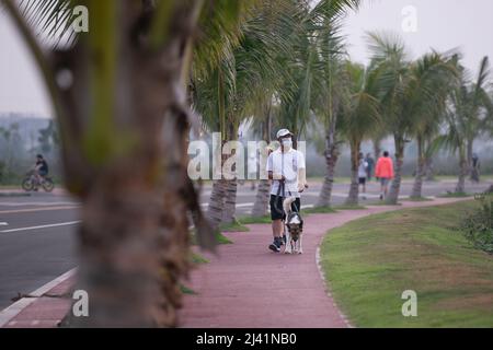 Vientiane, Laos. 10. April 2022. Ein Bürger läuft mit seinem Hund in der Innenstadt von Vientiane, Laos, 10. April 2022. Kredit: Kaikeo Saiyasane/Xinhua/Alamy Live Nachrichten Stockfoto