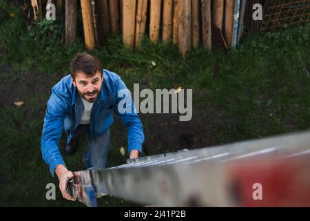 Aus der Perspektive eines reifen Mannes, der die Leiter hochklettert Stockfoto