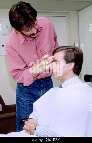 Jan Hofer, deutscher Nachrichtensprecher und Moderator, wird in der Maske geschminkt im Studio der Tagesschau, Deutschland um 1988. Stockfoto