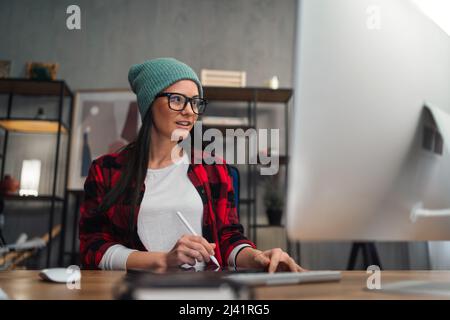 Glückliche weibliche Video-Editor arbeitet drinnen in kreativen Büro-Studio Stockfoto