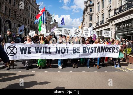 Extinction Rebellion Protestierende startenden in London ab dem 9. April 2022 eine Phase ziviler Störungen. Marschieren Sie die Regent Street mit einem Transparent entlang Stockfoto