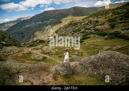 Ein Mädchen, das im Sommer in den Bergen wandert Stockfoto
