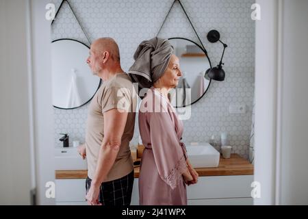 Seniorenpaar im Badezimmer, Rücken an Rücken stehend, Beziehungsprobleme Konzept. Stockfoto