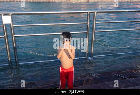 Junges Kind, das am Morgen eine religiöse Pryer des Flusses aus flachem Winkel Bild macht, wird bei haridwar uttrakhand india aufgenommen. Stockfoto