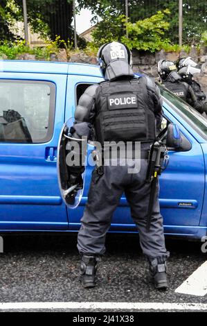 Belfast, Nordirland. 21/06/2013. Ein Polizeibeamter, der mit einem Schild in einen Bereitschaftstrikot gekleidet ist, hält ein Fahrzeug an Stockfoto