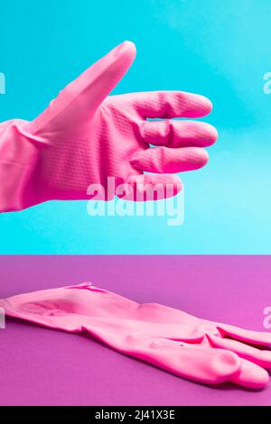 Hand in rosa Latex-Handschuh in Position zum Schütteln. Handschlag. Reinigungs- und Gesundheitskonzept Stockfoto