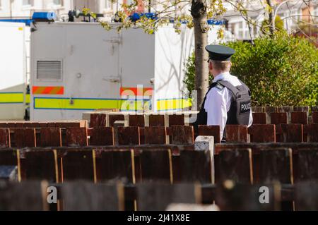 Belfast, Großbritannien. 05/04/2012 - Polizeibeamter steht Wache während eines Sicherheitsalarms in Ardoyne. Das Objekt wurde später zum Schwindel erklärt. Stockfoto