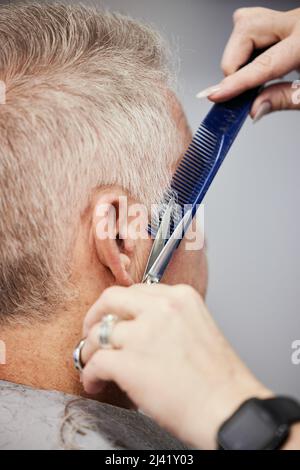 Immer einen frischen neuen Schnitt. Aufnahme eines Mannes, der in einem Salon einen Haarschnitt bekommt. Stockfoto