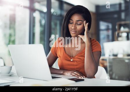Heute war mehr als stressig. Aufnahme einer attraktiven jungen Geschäftsfrau, die an Kopfschmerzen in ihrem Büro leidet. Stockfoto