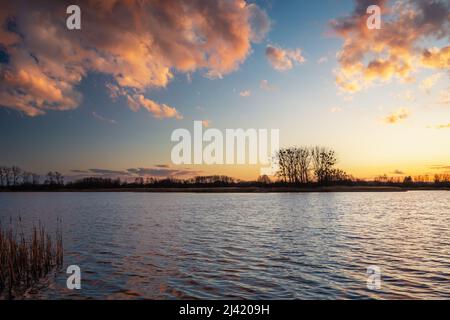 Bunte Wolken nach dem Sonnenuntergang über dem See Stockfoto