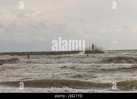 Wellen schlagen am Leuchtturm des Hafens von Sotogrande. Costa del Sol, Andalusien, Spanien. Stockfoto