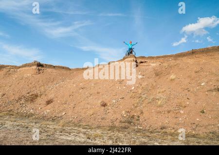 Ein Radler fährt auf einem Schotterfahrrad am Klippenrand in der Colorado Prairie - Naturgebiet Soapstone Prairie Stockfoto