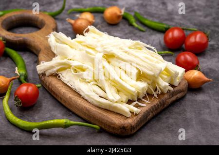 Cecil oder String Cheese auf dunklem Boden. Köstliche Käsesortiment. Nahaufnahme Stockfoto