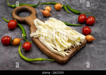 Cecil oder String Cheese auf dunklem Boden. Köstliche Käsesortiment. Nahaufnahme Stockfoto