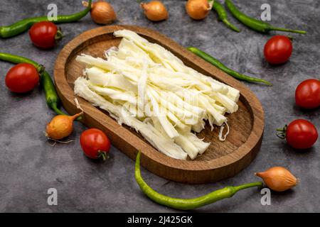 Cecil oder String Cheese auf dunklem Boden. Köstliche Käsesortiment. Nahaufnahme Stockfoto