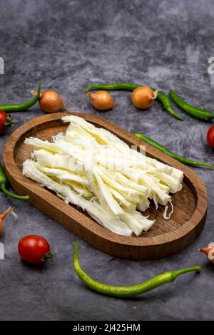 Cecil oder String Cheese auf dunklem Boden. Köstliche Käsesortiment. Nahaufnahme Stockfoto