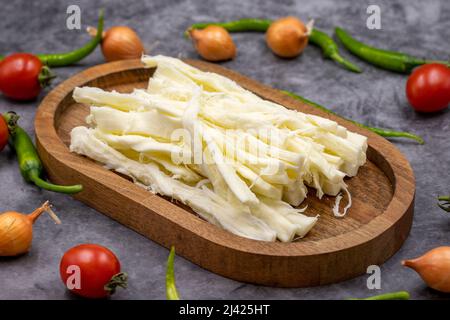 Cecil oder String Cheese auf dunklem Boden. Köstliche Käsesortiment. Nahaufnahme Stockfoto