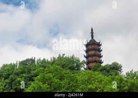 Die Cishou-Pagode erhebt sich an einem bewölkten Tag in der Provinz Jiangsu über den Bäumen im malerischen Gebiet des Jinshan-buddhistischen Tempels in Zhenjiang China. Stockfoto