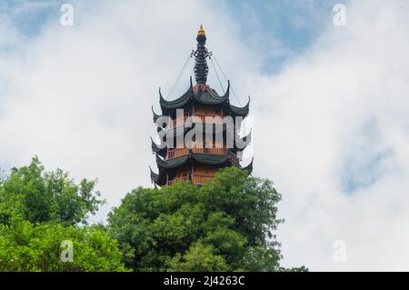 Die Cishou-Pagode erhebt sich an einem bewölkten Tag in der Provinz Jiangsu über den Bäumen im malerischen Gebiet des Jinshan-buddhistischen Tempels in Zhenjiang China. Stockfoto