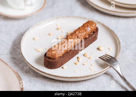 Schokoladenkuchen mit Haselnussbröseln auf hellem Hintergrund. Stockfoto