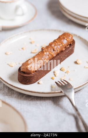 Schokoladenkuchen mit Haselnussbröseln auf hellem Hintergrund. Stockfoto