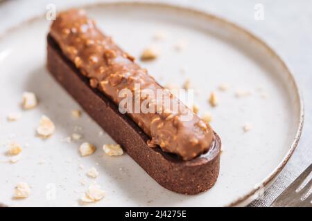 Schokoladenkuchen mit Haselnussbröseln auf hellem Hintergrund. Stockfoto