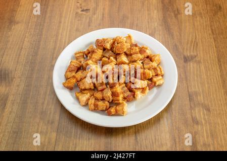 Typisch spanische Tapa von torreznos de soria in Olivenöl auf Holztisch gebraten Stockfoto