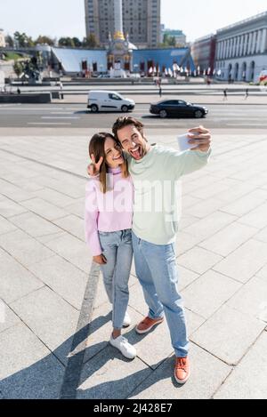 Positives Paar, das auf der städtischen Straße gestikelt und Selfie gemacht hat Stockfoto