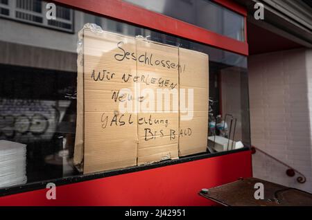 Offenbach, Deutschland. 11. April 2022. Im Fenster eines vorübergehend geschlossenen Fast-Food-Restaurants in der Innenstadt von Offenbach steht ein Schild mit der Aufschrift „Geschlossen“. Wir legen eine neue Gasleitung an. Bis bald“. Kredit: Frank Rumpenhorst/dpa/Alamy Live Nachrichten Stockfoto