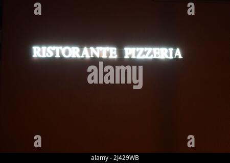 Neonlichter Inschrift in italienischen sagen Pizza Restaurant oder Pizzeria. Die Neonlichter sind weiß auf dem schwarzen Hintergrund. Viel Speicherplatz für Kopien. Stockfoto