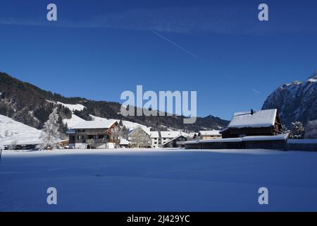 Dorf Studen, Schweiz im Winter. Es liegt zwischen schneebedeckten Feldern. Es ist ein beliebtes Langlaufzentrum im Kanton Schwyz. Stockfoto