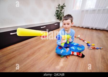 Eine Kugel oder Rakete aus Schaumstoff fliegt aus einem Spielzeug-Maschinengewehr. Stockfoto